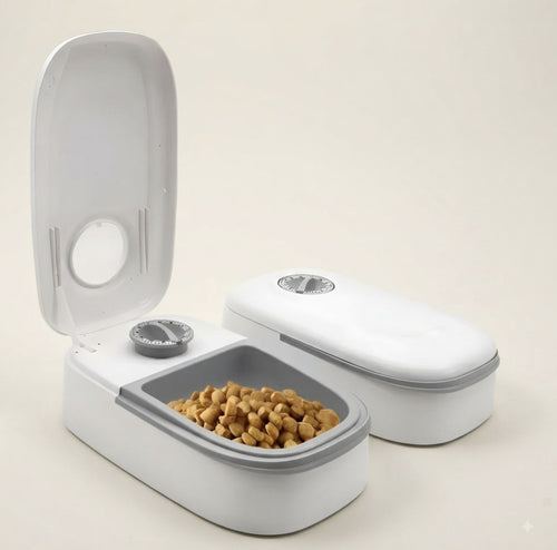 Comedero automático doble para mascotas con temporizador, sobre fondo crema