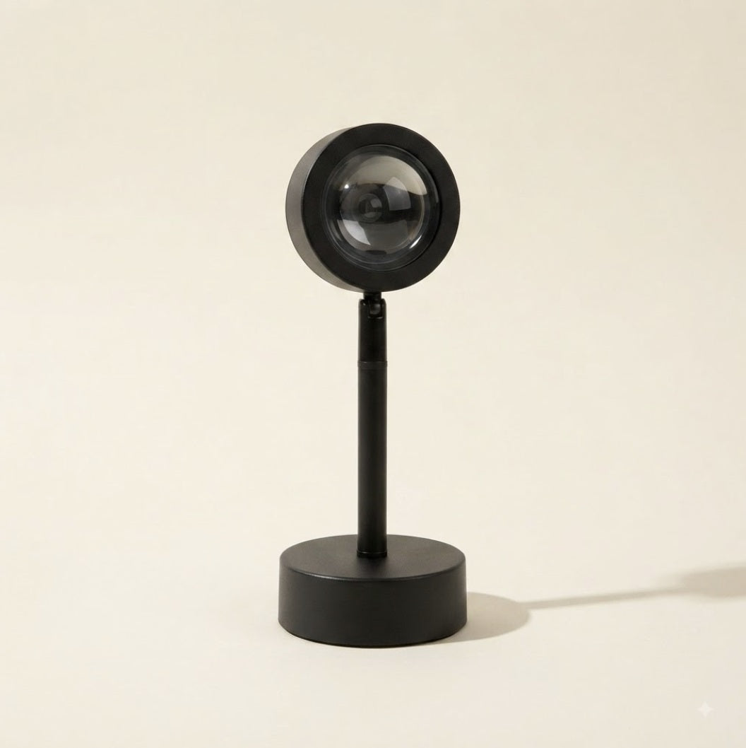 Lámpara proyector de atardecer negra sobre soporte, sobre fondo crema